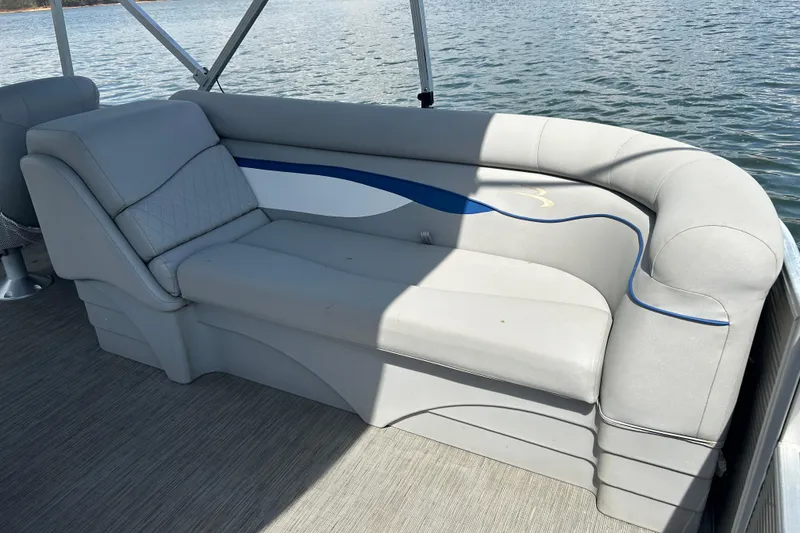 Slide: The Image of 2023 Bennington 22 SSR boat interior with gray seating and blue accents on a sunny day. - 18
