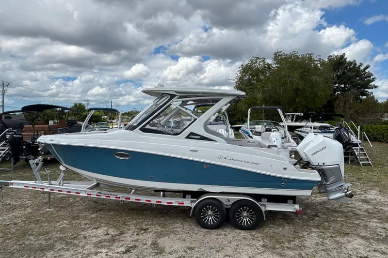 The Image of 2026 Crownline 280 DC boat on trailer, blue hull, outboard motor. - 0