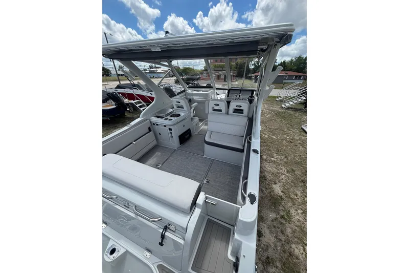 Slide: The Image of 2026 Crownline 280 DC boat interior with seating and helm, under a cloudy sky. - 10