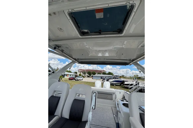 Slide: The Image of Interior view of 2026 Crownline 280 DC boat, featuring seating and open sunroof. - 24
