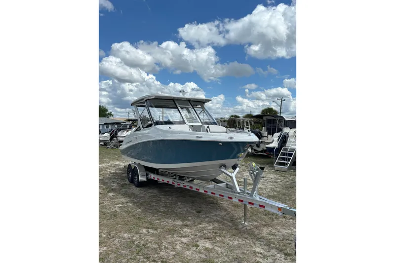 Slide: The Image of 2026 Crownline 280 DC boat on trailer under a cloudy sky. - 8