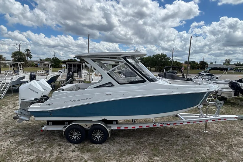 Slide: The Image of 2026 Crownline 280 DC boat on trailer under cloudy sky. - 9