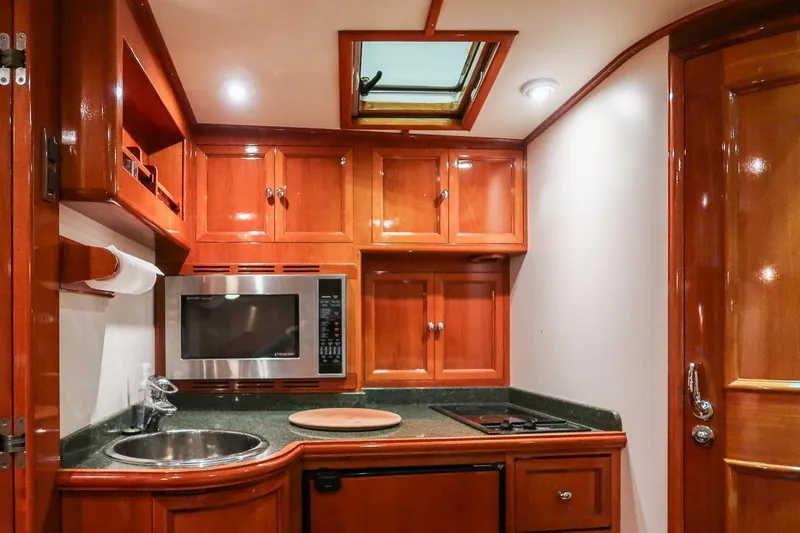 Slide: The Image of Luxurious 2007 Grand Banks 39 Eastbay SX yacht kitchen with wood cabinetry and modern appliances. - 28