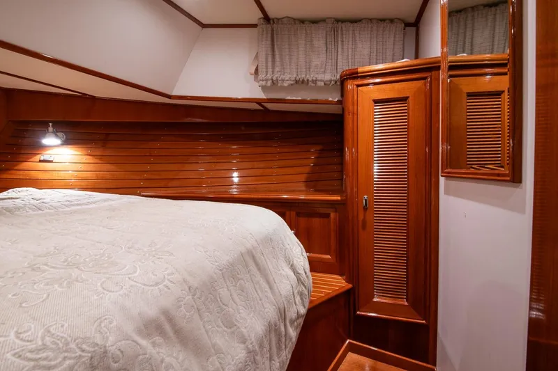 Slide: The Image of Luxurious 2007 Grand Banks 39 Eastbay SX cabin with elegant wood paneling and cozy bedding. - 33