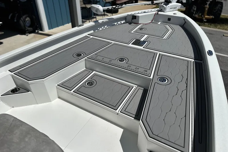 Slide: The Image of 2024 Avid 23 Mag boat deck with gray non-slip surface and storage compartments. - 18
