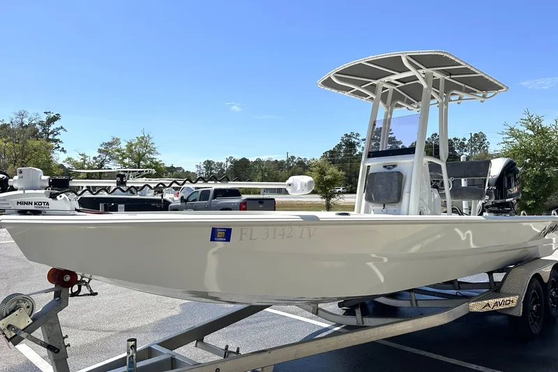 Slide: The Image of 2024 Avid 23 Mag boat on trailer, featuring Minn Kota trolling motor. - 5