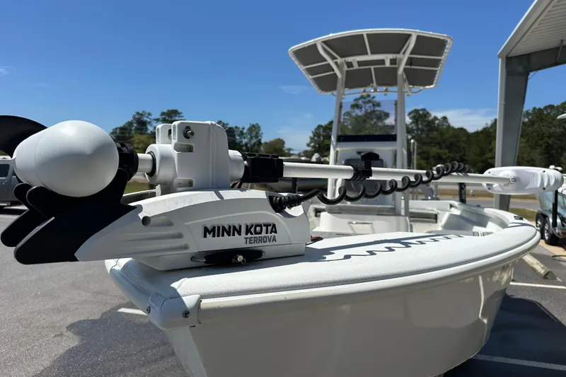 Slide: The Image of 2024 Avid 23 Mag boat with Minn Kota Terrova trolling motor, parked outdoors. - 8