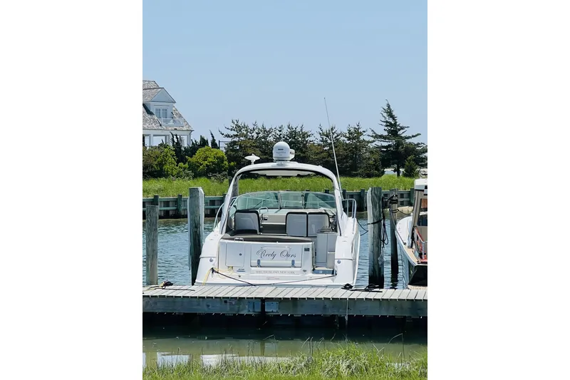 Slide: The Image of 2017 Sea Ray Sundancer 370 docked at a marina with lush greenery. - 9