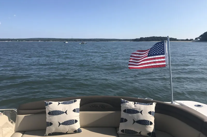 Slide: The Image of Sea Ray Sundancer 370 boat with American flag and fish-patterned pillows on a sunny day. - 13