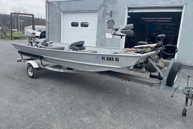 Slide: The Image of 1980 Lowe Big Jon 16 boat on trailer, parked outside a garage. - 3