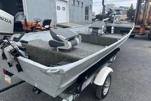 Slide: The Image of 1980 Lowe Big Jon 16 boat on trailer, featuring Honda outboard motor and cushioned seating. - 6