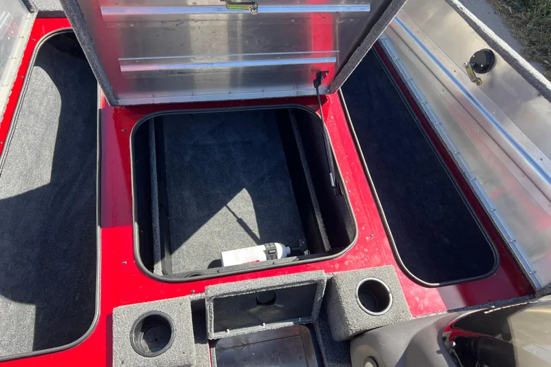 Slide: The Image of 2020 Tracker Pro Team 175 TXW boat storage compartments, open and empty, with red and gray interior. - 12