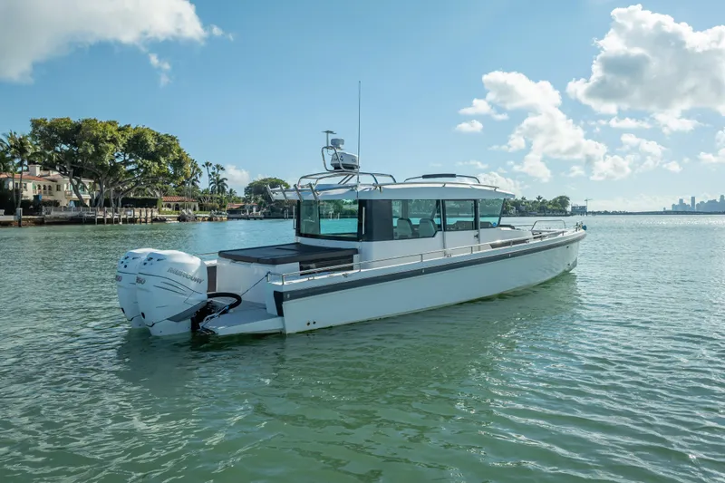 Slide: The Image of 2017 Axopar 37 XC Cross Cabin boat on calm water under a clear sky. - 4