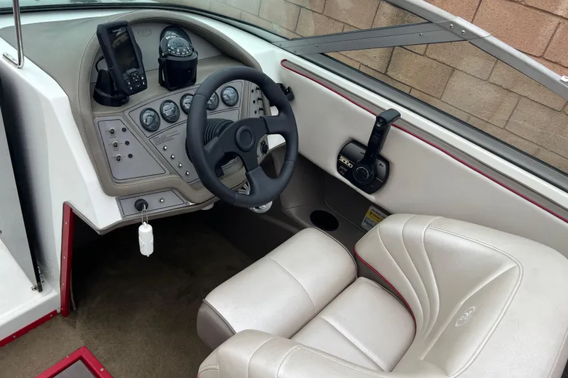 Slide: The Image of Interior of a 1996 Cobalt 220 boat showing steering wheel and control panel. - 12