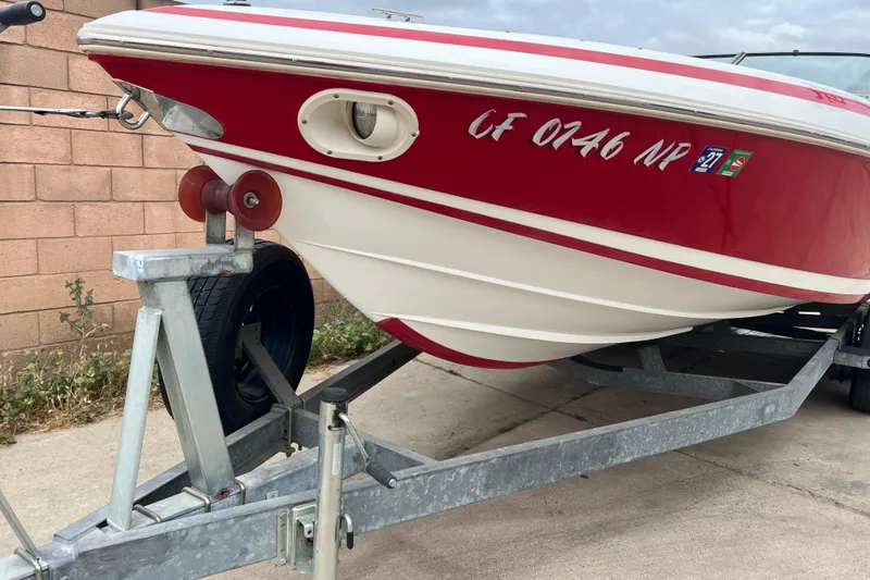 Slide: The Image of Red and white 1996 Cobalt 220 boat on trailer, parked on concrete surface. - 4