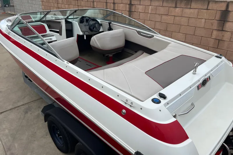 Slide: The Image of Red and white 1996 Cobalt 220 boat on trailer, parked near a brick wall. - 6