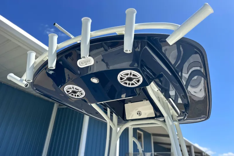 Slide: The Image of T-top of 2026 Pathfinder 2400 TRS boat with rod holders and speakers against blue sky. - 16