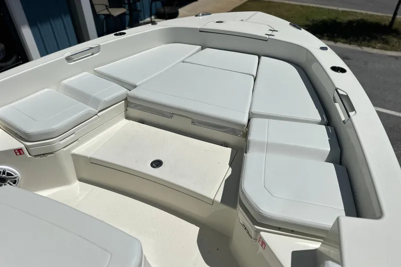 Slide: The Image of 2026 Pathfinder 2400 TRS boat interior with white cushioned seating and storage compartments. - 19