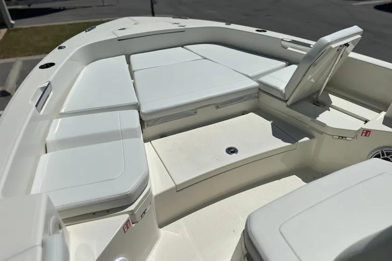 Slide: The Image of 2026 Pathfinder 2400 TRS boat interior with white cushioned seating and storage compartments. - 2