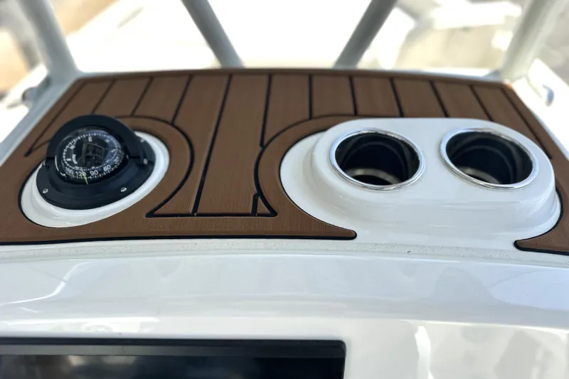 Slide: The Image of 2026 Pathfinder 2400 TRS boat dashboard with compass and cup holders. - 23