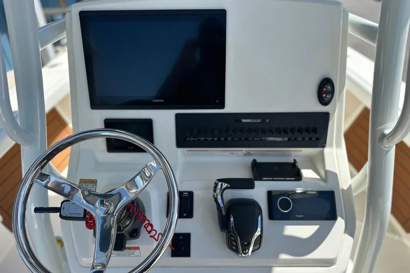 Slide: The Image of 2026 Pathfinder 2400 TRS boat console with steering wheel and electronic controls. - 3