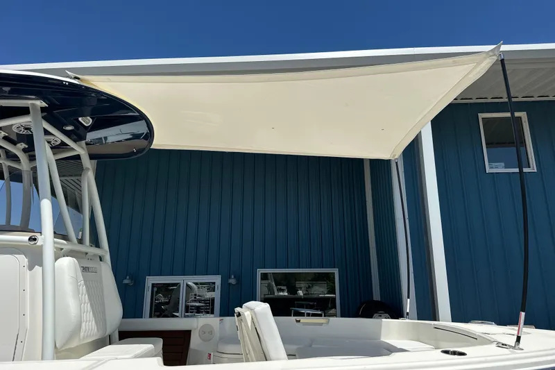 Slide: The Image of 2026 Pathfinder 2400 TRS boat with canopy, docked near blue building. - 7