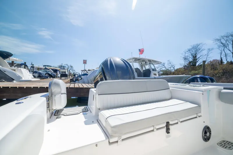 Slide: The Image of 2024 Sea Fox 248 Commander boat interior with seating, docked under clear blue sky. - 21