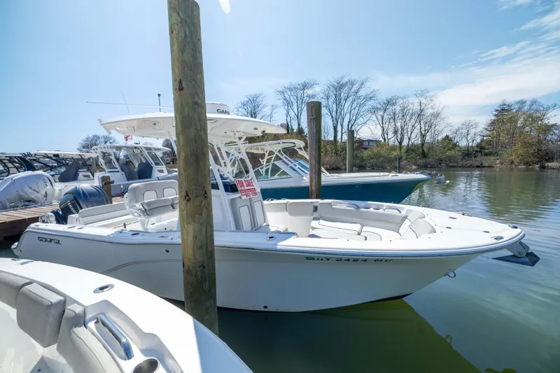 Slide: The Image of 2024 Sea Fox 248 Commander boat docked, for sale sign visible, calm waters, clear sky. - 25