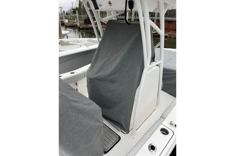 Slide: The Image of 2024 Sea Fox 248 Commander boat interior with protective covers, docked at marina. - 6