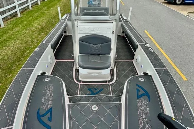 Slide: The Image of 2015 Robalo 226 Cayman boat with AquaTraction flooring, featuring a central seat and spacious deck. - 15