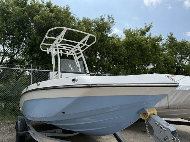 The Image of 2025 Yamaha Boats 195 FSH Sport on trailer, blue hull, outdoors. - 1