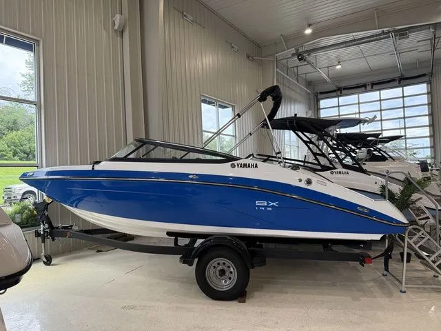 Slide: The Image of 2025 Yamaha SX195 boat in blue and white displayed indoors. - 2