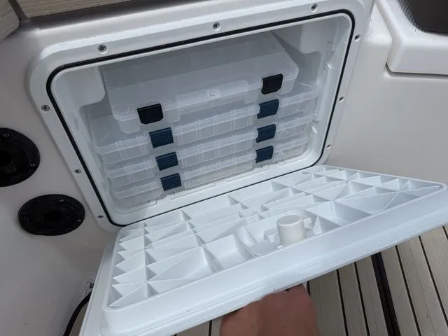 Slide: The Image of Yamaha 195 FSH Sport 2025, open storage compartment with plastic containers. - 15