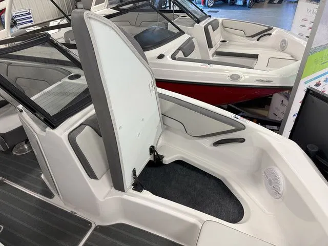 Slide: The Image of 2024 Yamaha Boats SX190 with open storage compartment lid. - 24