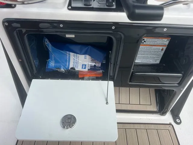 Slide: The Image of Storage compartment in 2024 Yamaha Boats 190 FSH Sport with safety gear. - 12