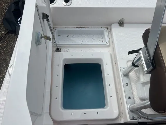 Slide: The Image of 2024 Yamaha Boats 190 FSH Sport interior view with storage compartment. - 14