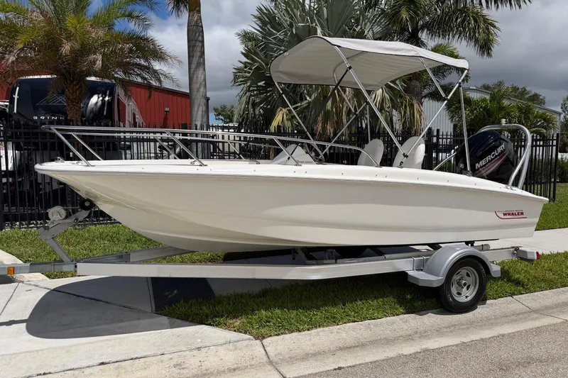 The Image of 2017 Boston Whaler 170 Super Sport boat on trailer, parked near palm trees. - 0