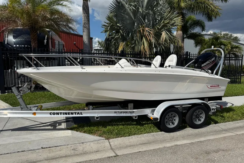 The Image of 2017 Boston Whaler 170 Super Sport boat on trailer, parked outdoors with palm trees. - 1