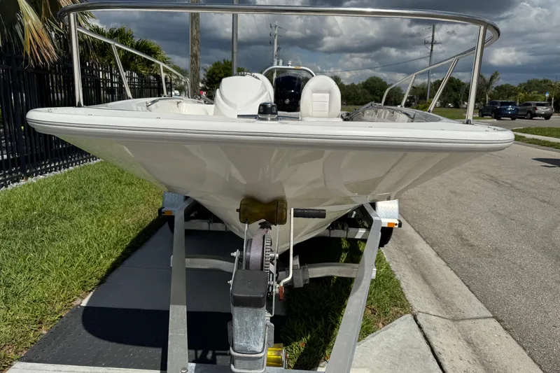 Slide: The Image of 2017 Boston Whaler 170 Super Sport boat on trailer, parked on roadside. - 11