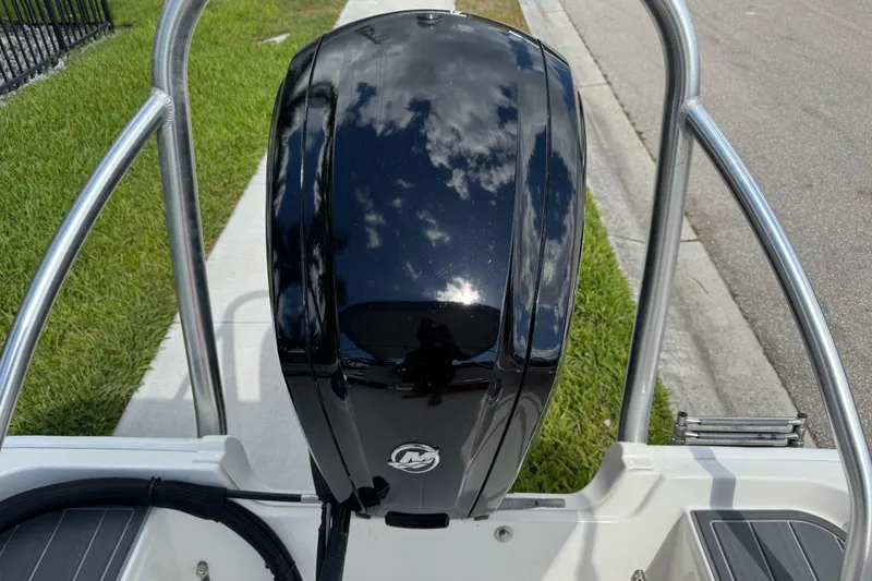 Slide: The Image of 2017 Boston Whaler 170 Super Sport boat engine, shiny black finish, outdoor setting. - 13
