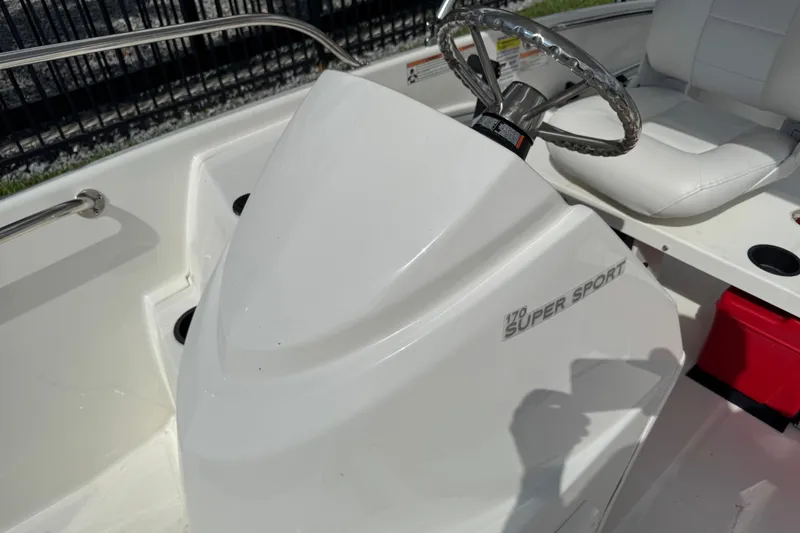 Slide: The Image of 2017 Boston Whaler 170 Super Sport boat interior with steering wheel and seating. - 17
