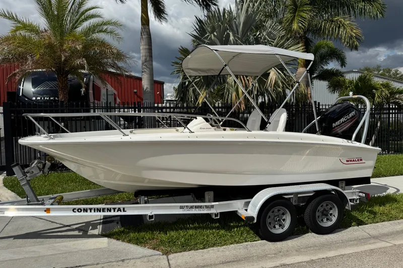 Slide: The Image of 2017 Boston Whaler 170 Super Sport boat on trailer, parked near palm trees. - 20