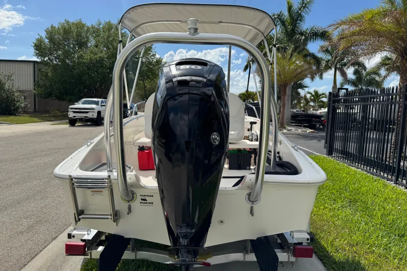 Slide: The Image of 2017 Boston Whaler 170 Super Sport boat with outboard motor, parked on a sunny street. - 24