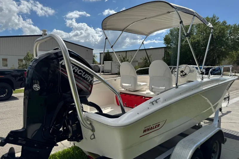 Slide: The Image of 2017 Boston Whaler 170 Super Sport boat with Mercury engine and canopy on trailer. - 25