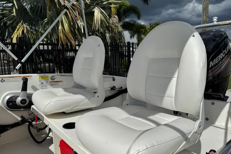 Slide: The Image of 2017 Boston Whaler 170 Super Sport boat interior with white seats and Mercury engine. - 29