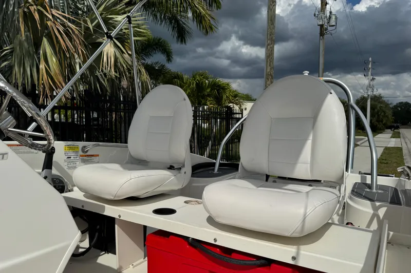 Slide: The Image of 2017 Boston Whaler 170 Super Sport boat interior with white seats and steering wheel. - 38