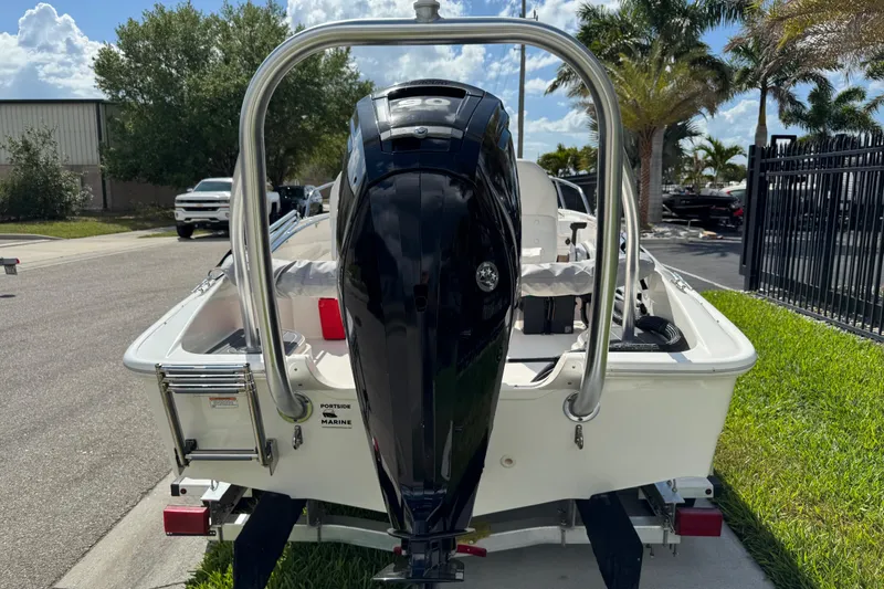 Slide: The Image of 2017 Boston Whaler 170 Super Sport boat with outboard motor, parked outdoors. - 6