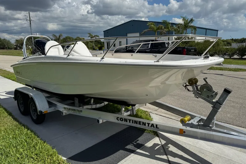 Slide: The Image of 2017 Boston Whaler 170 Super Sport boat on trailer, parked outdoors under cloudy sky. - 9