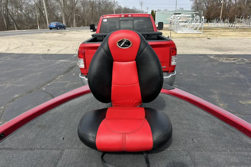 Slide: The Image of Red and black seat on a 2007 Skeeter 20i boat, parked near a red truck. - 15