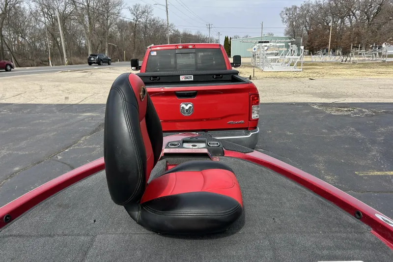 Slide: The Image of Red and black seat on a 2007 Skeeter 20i boat, parked behind a red truck. - 16